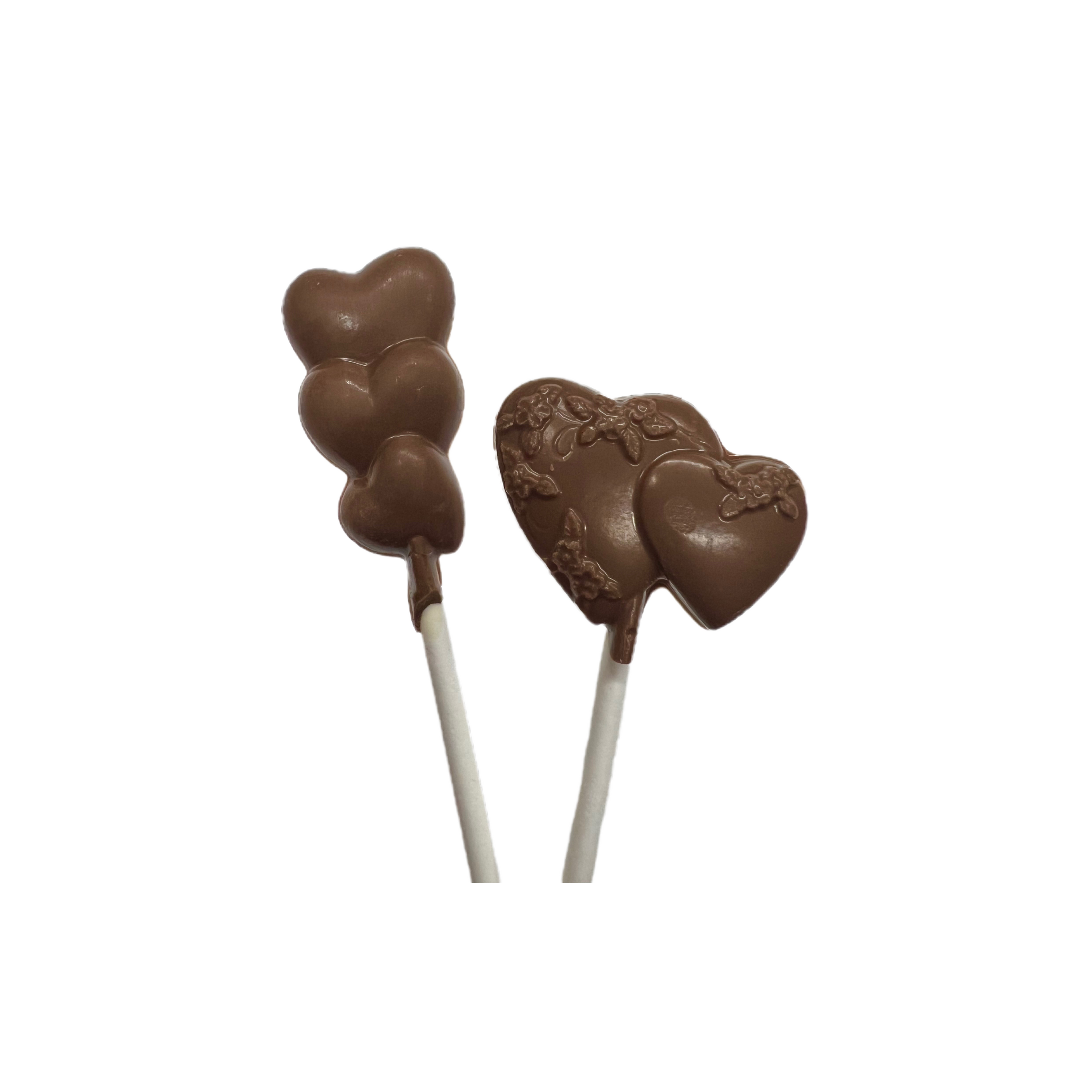 Two chocolate heart-shaped lollipops on sticks against a white background