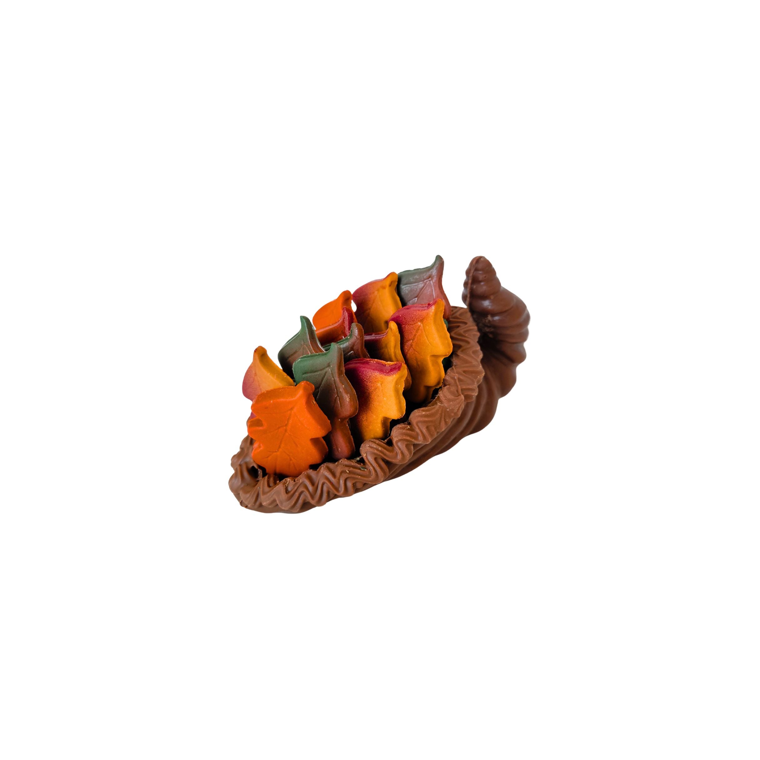 Decorative leaf-shaped chocolates holder with colorful candles on a white background