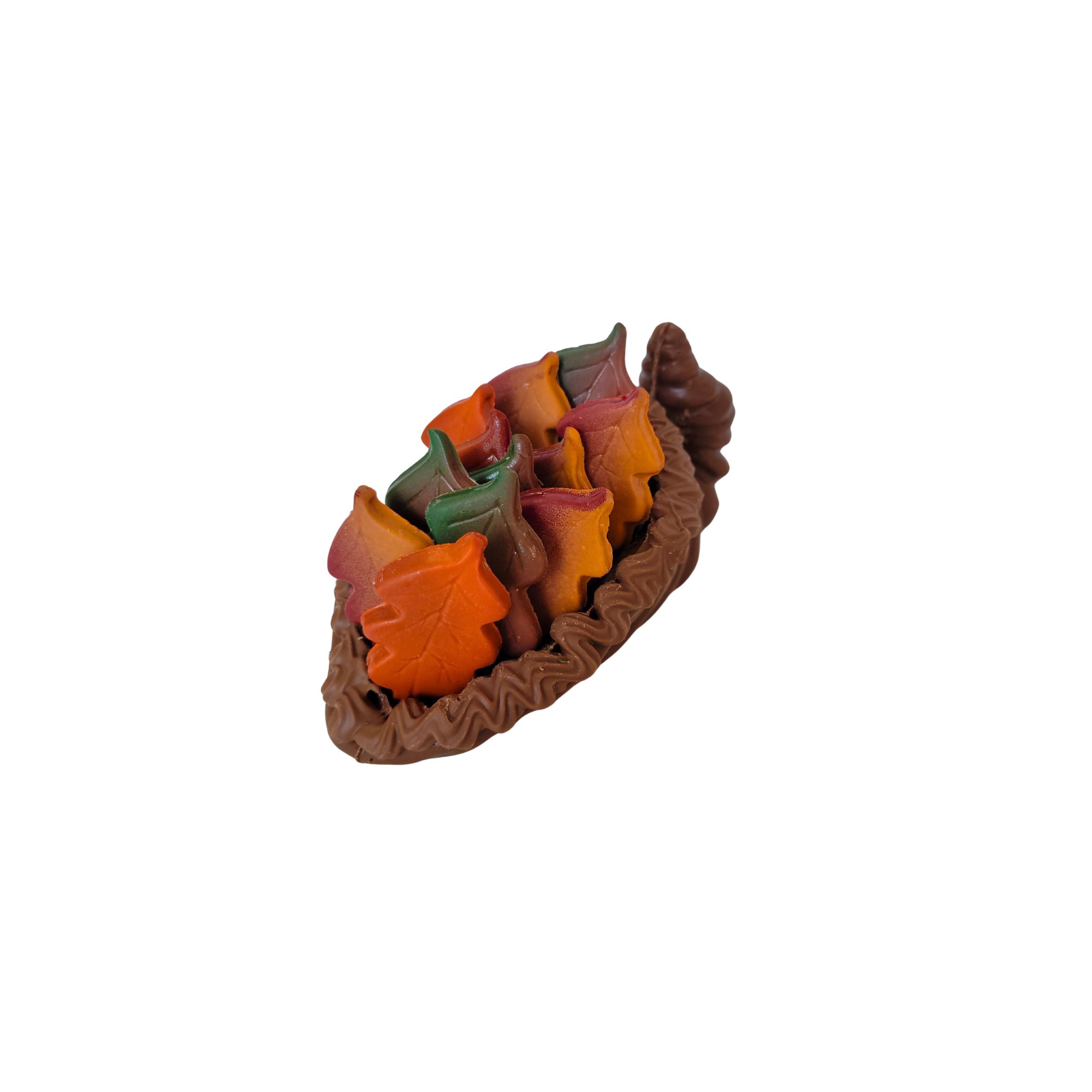 Decorative leaf-shaped chocolates in a basket on a white background
