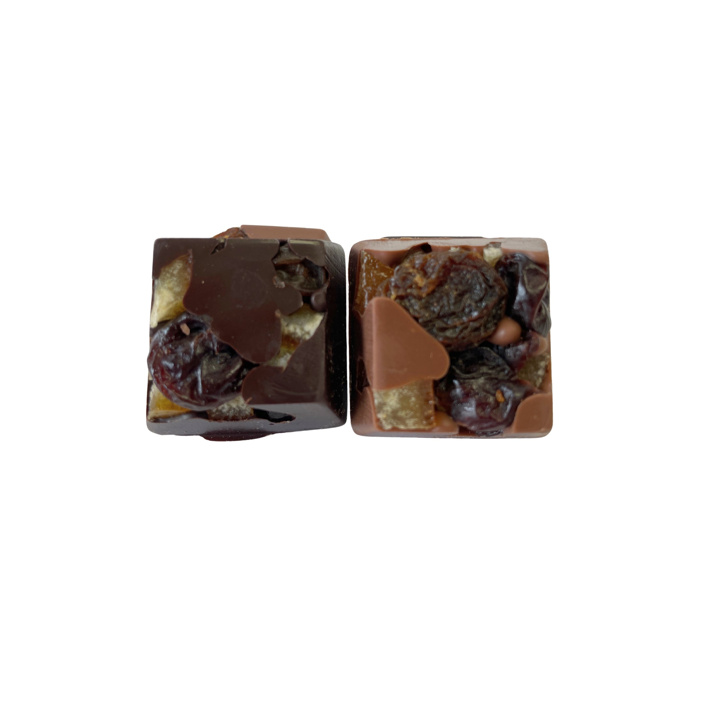 Two chocolate squares with dried fruits on a white background