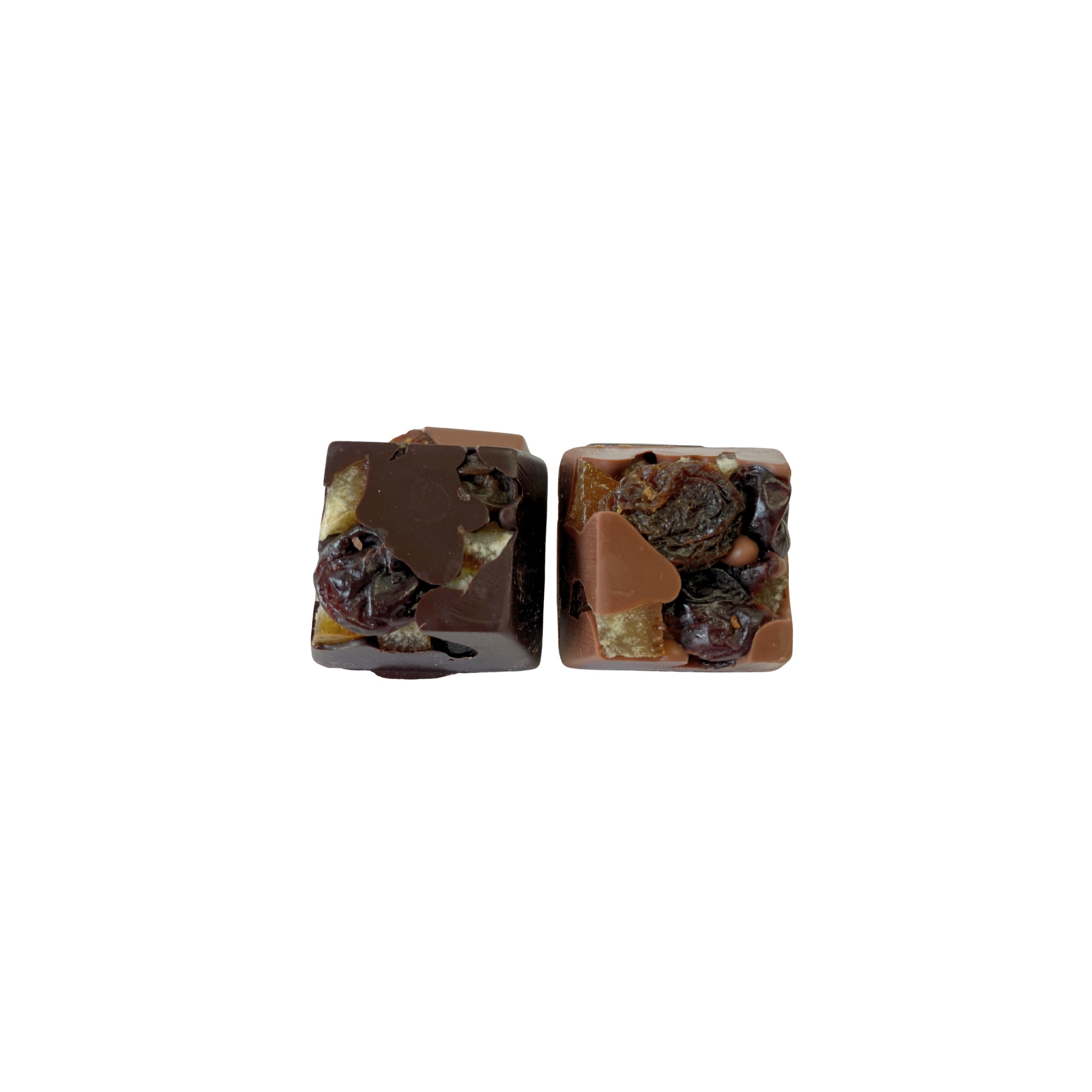 Two square chocolate pieces with visible nuts and fruit on a white background