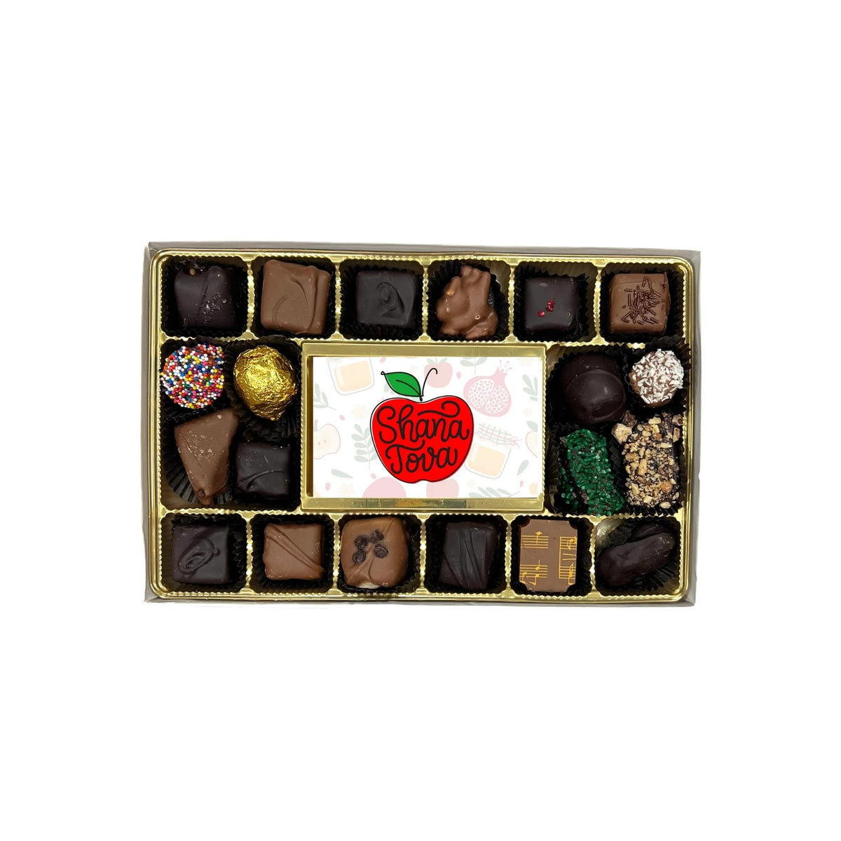 A boxed assortment of chocolates and truffles arranged in a gold tray, with a central white card featuring a red apple logo that reads 'Shana Tova'.