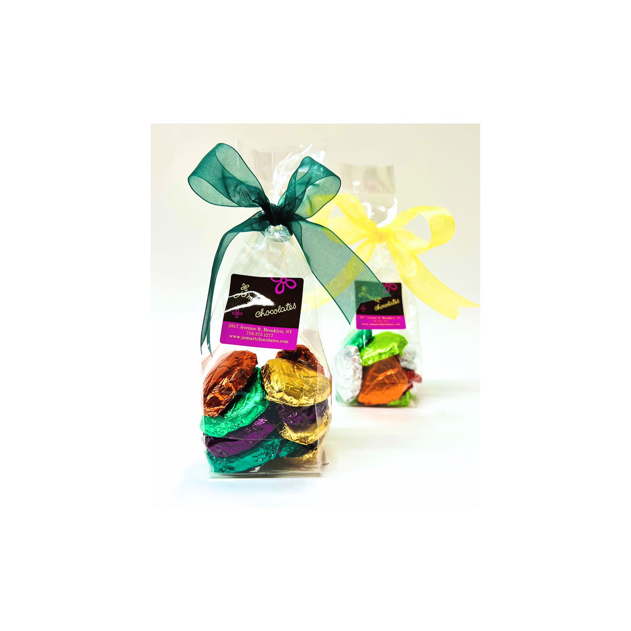 Two transparent gift bags with colorful contents and ribbons on a white background