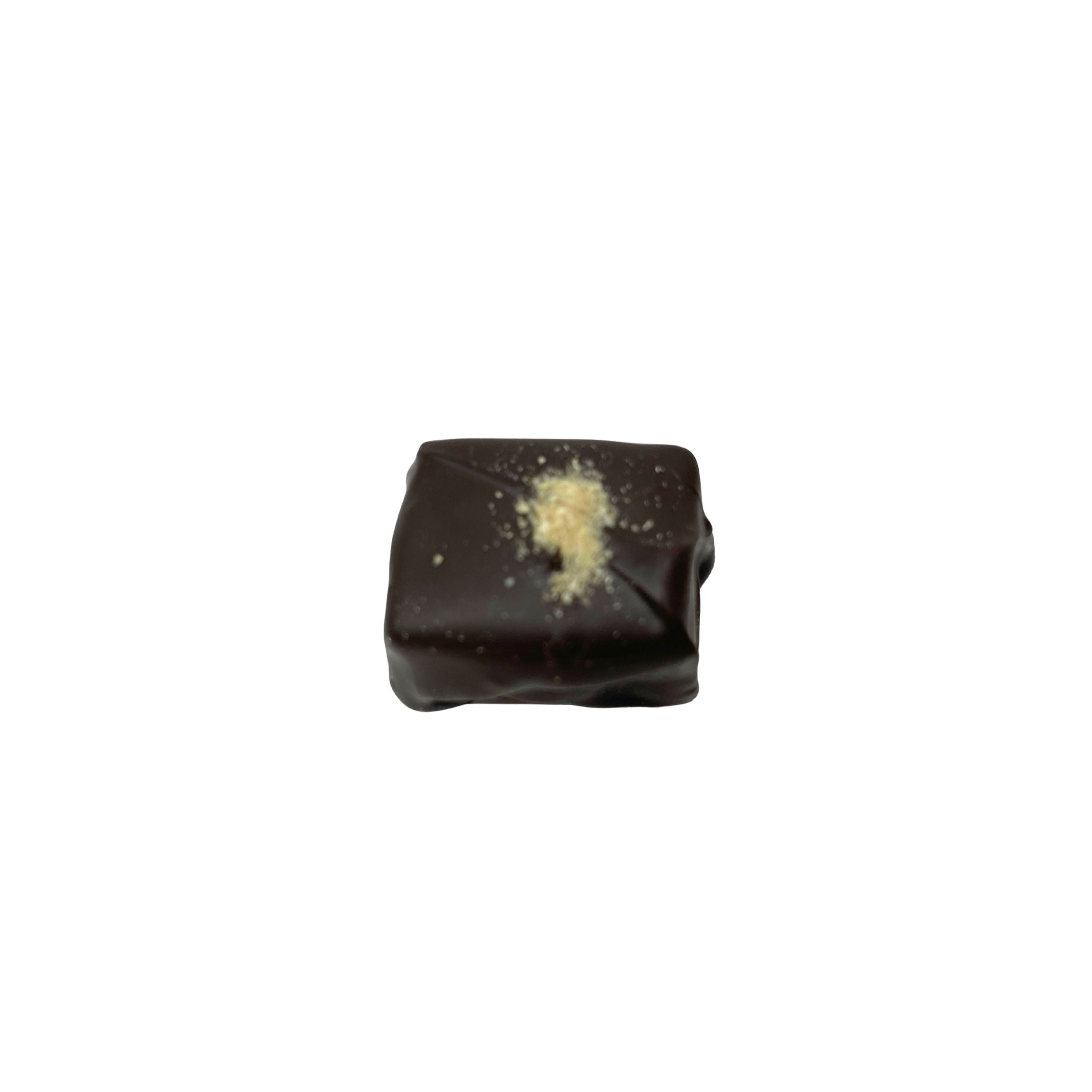 A single square dark chocolate candy with a light beige powdered topping, centered on a plain white background.