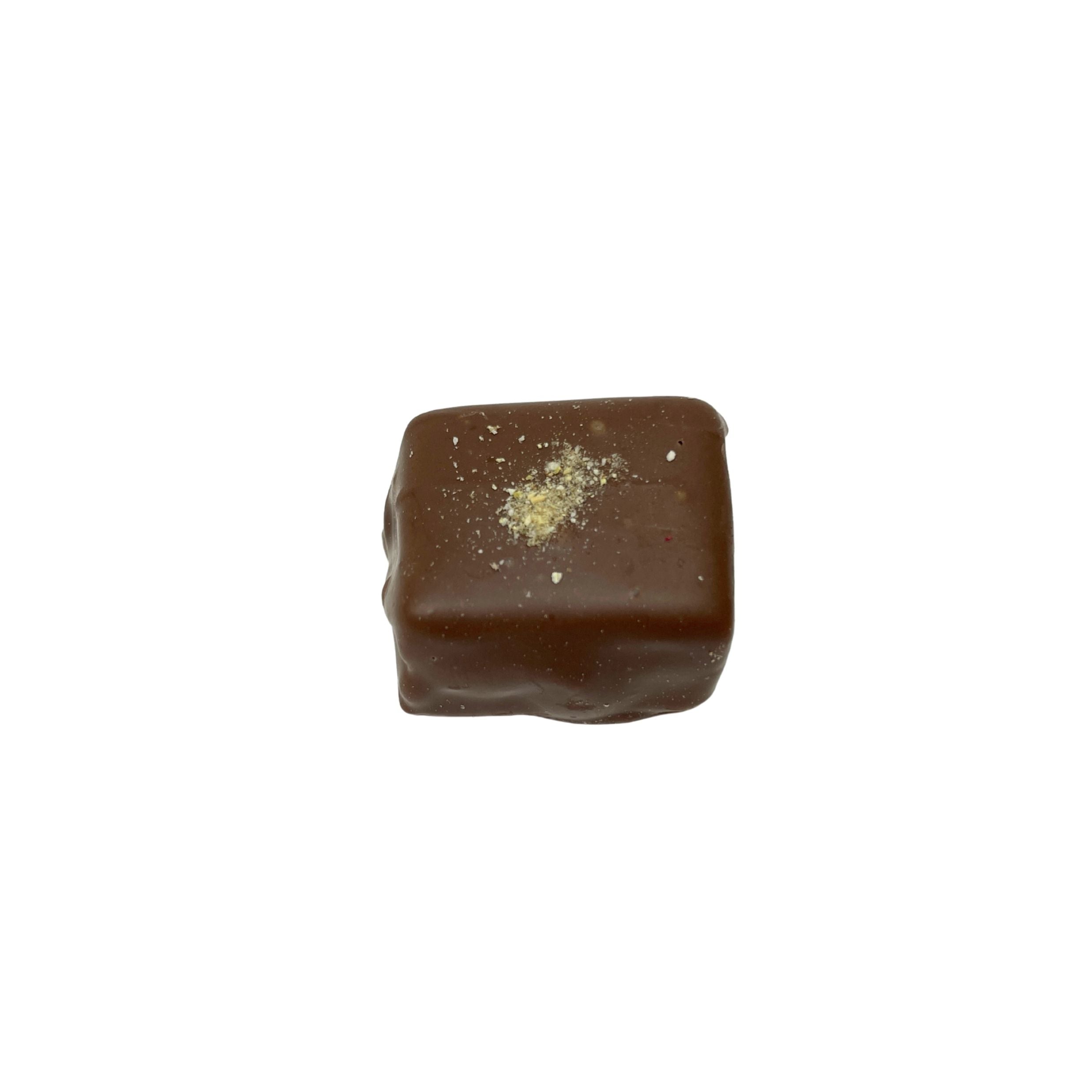 A single square dark brown chocolate candy with a small dusting of powdered sugar on top, isolated on a solid white background.