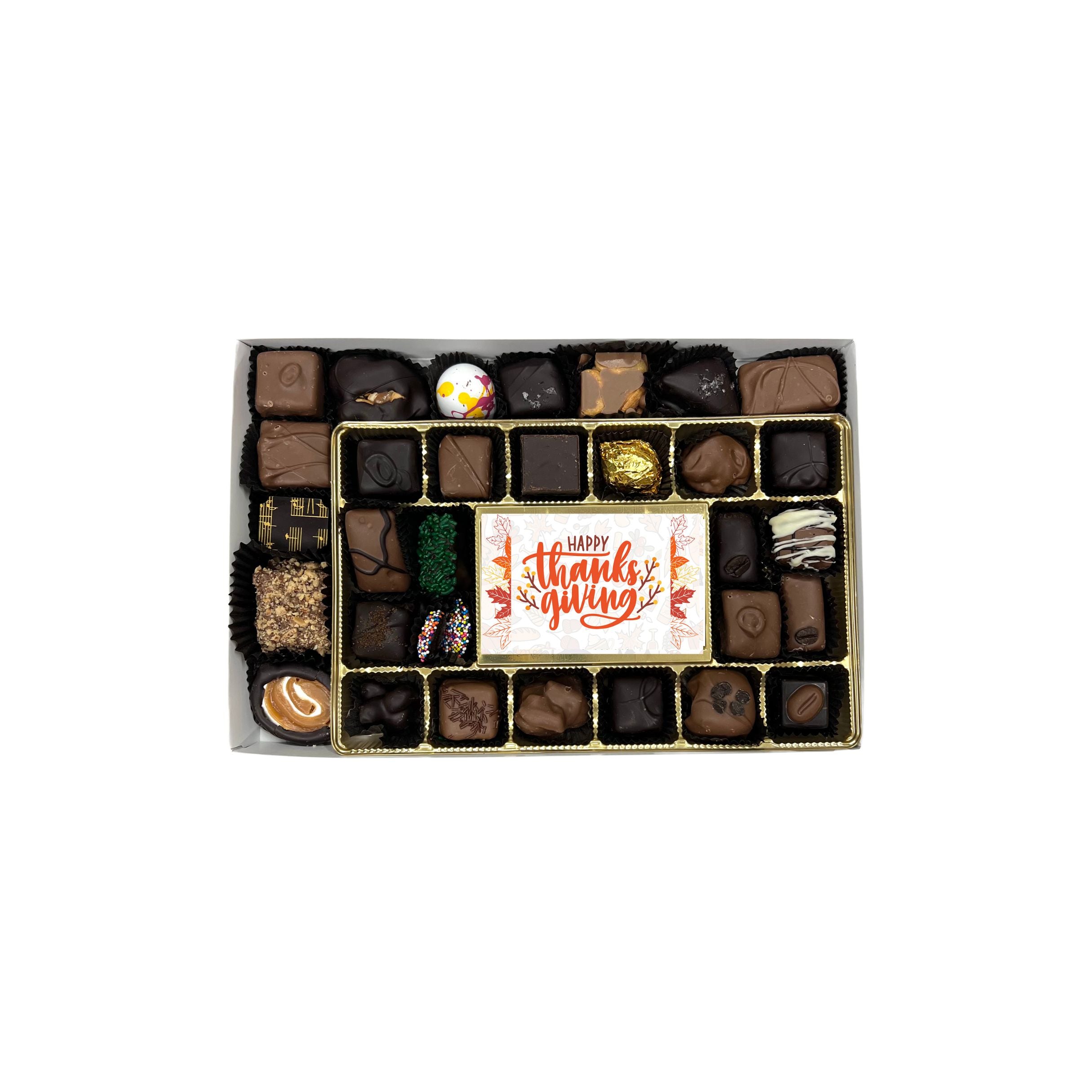 Box of assorted chocolates with a 'Happy Thanksgiving' card on a white background