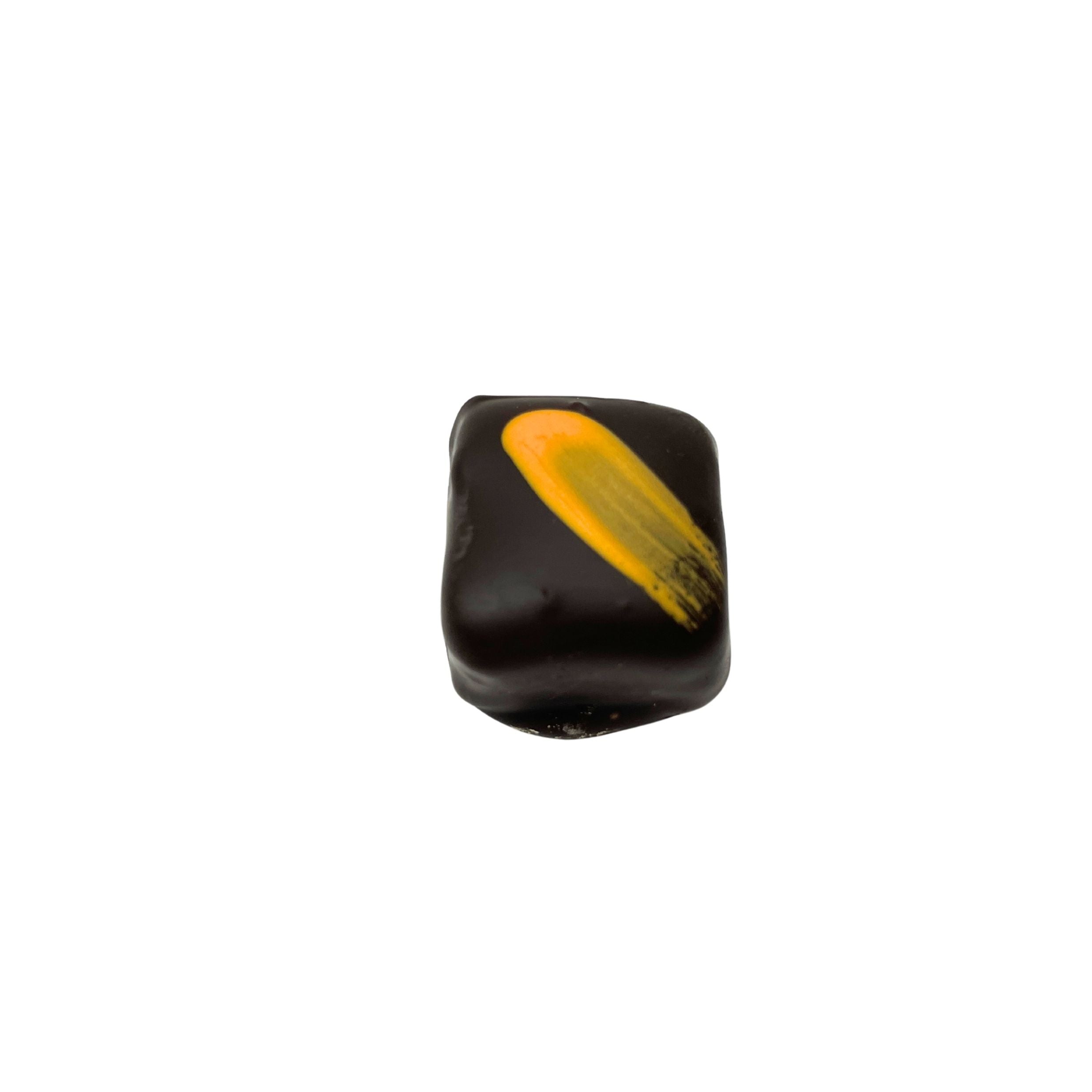 A single square chocolate bead with a textured yellow-orange brushstroke design on a plain white background.