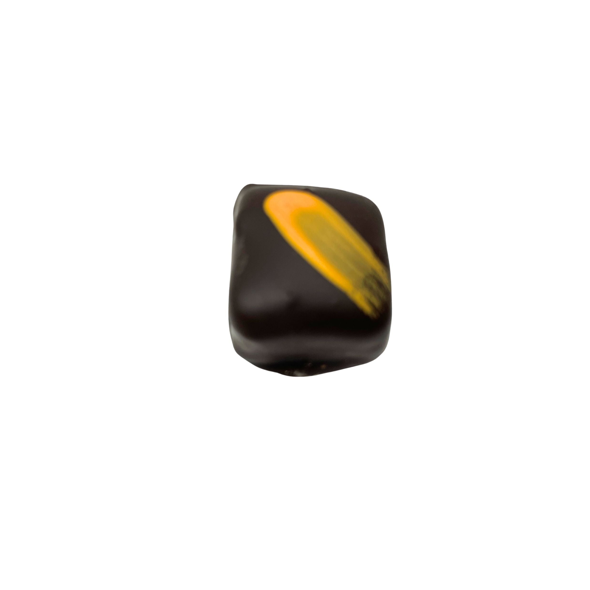 dark chocolate square confection with a yellow brush stroke on a white background
