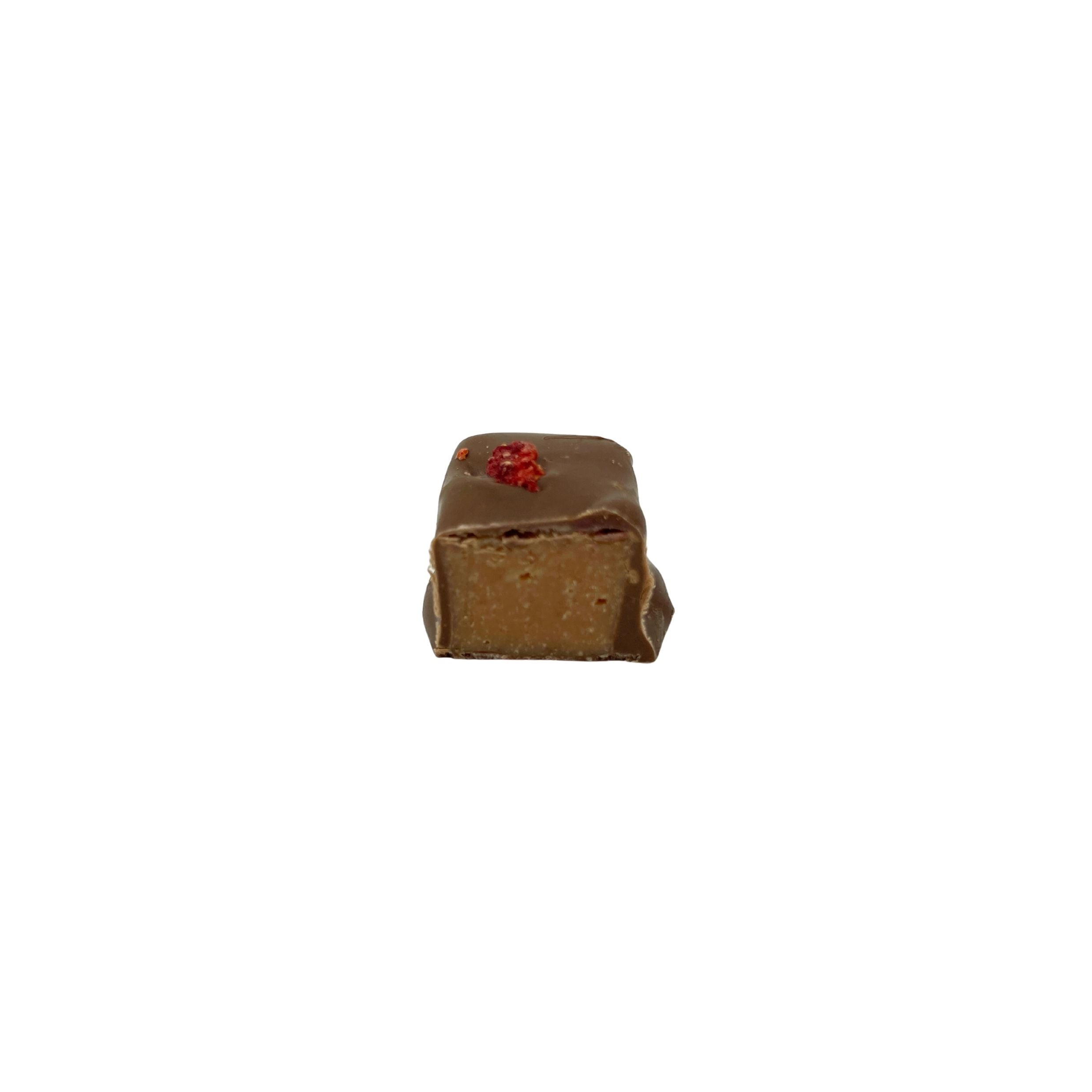 milk chocolate square confection with a chocolate filling with red speckle on top on a white background
