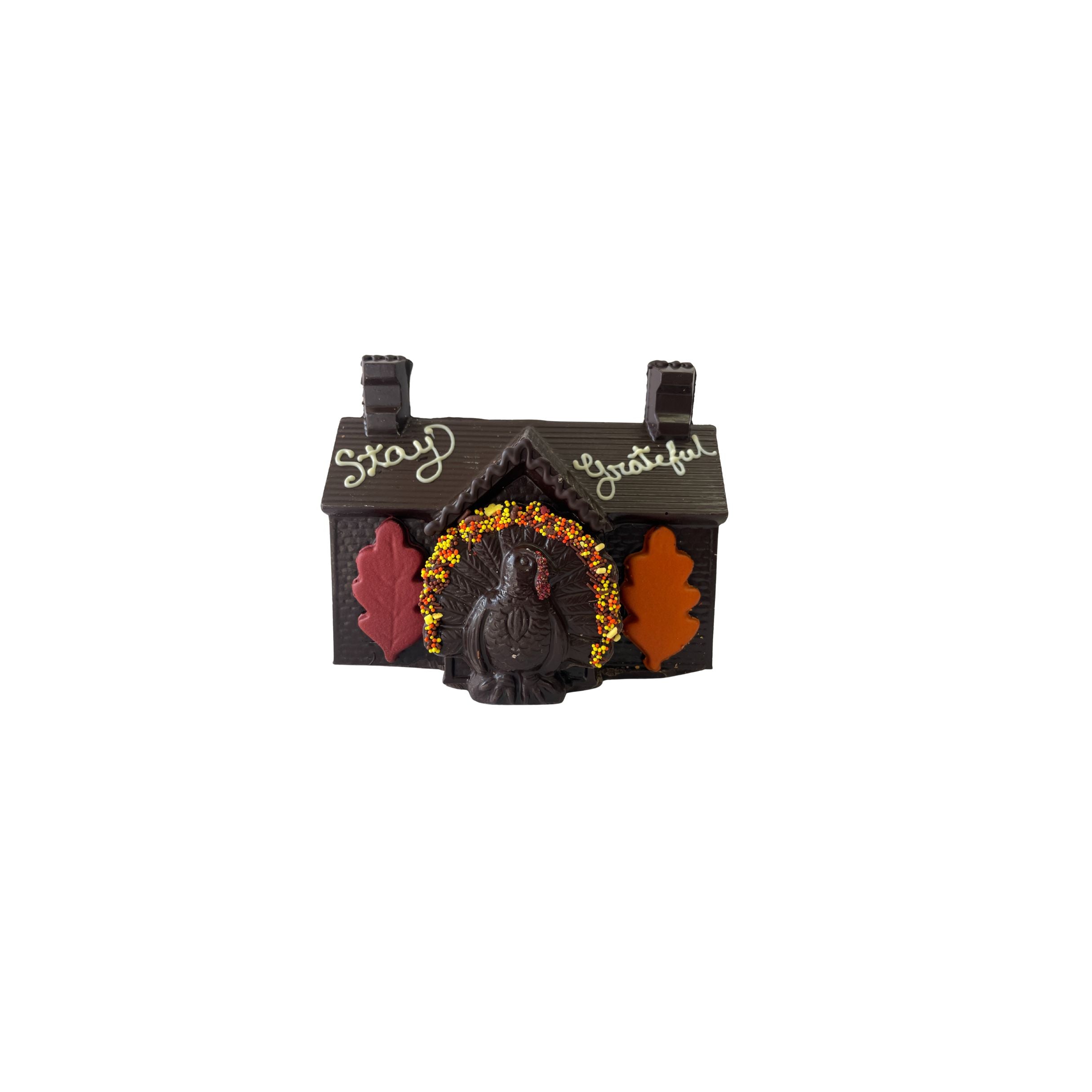 Decorative house-shaped chocolate with a turkey and autumn leaves on a white background