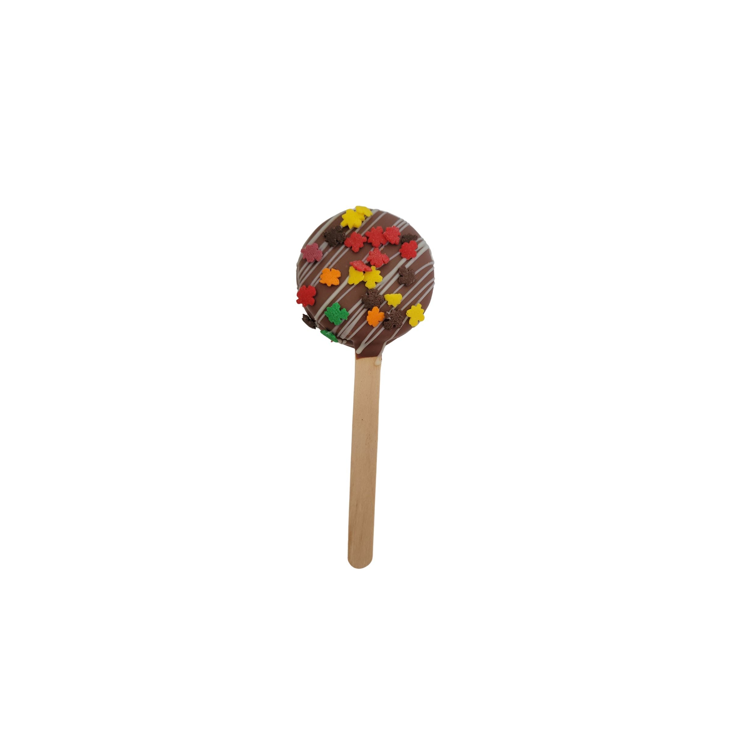Chocolate-covered popsicle with colorful sprinkles on a white background